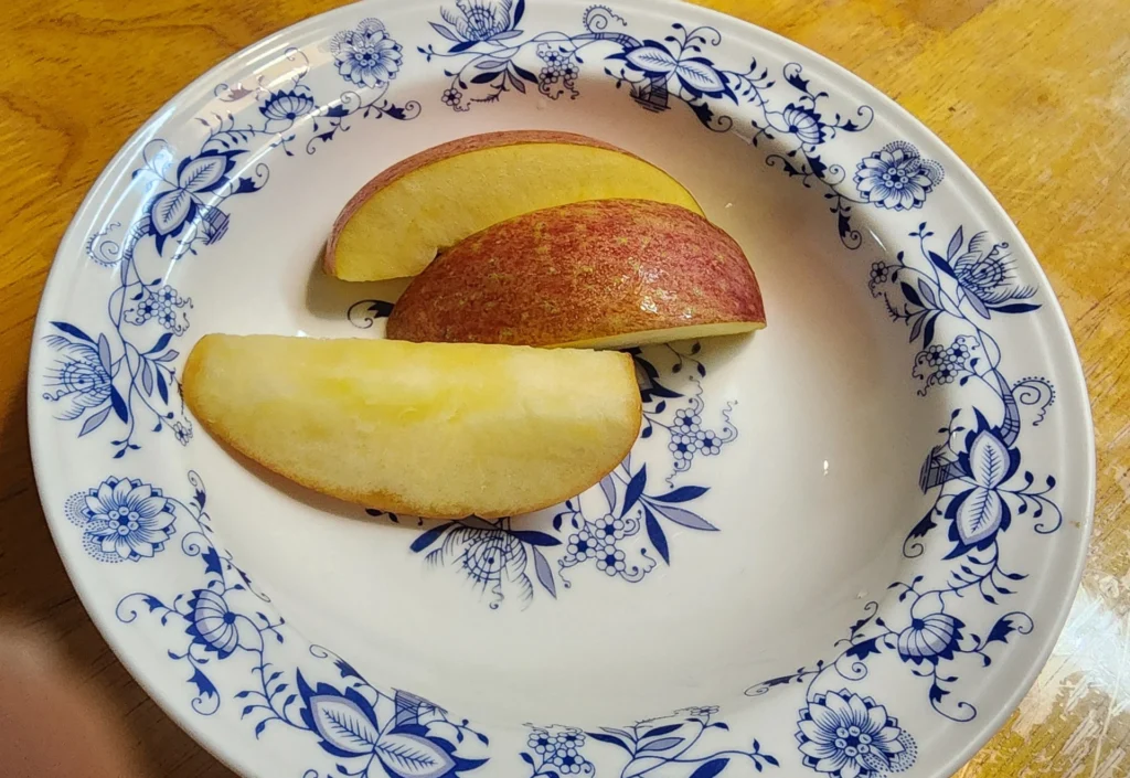 껍질 벗긴 사과 조각을 접시에 담은 사진