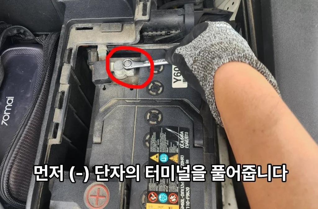 10mm 렌치로 배터리 (-) 단자 볼트를 분리하는 모습